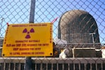 A sign warning of radioactive materials is attached to a fence outside a nuclear power plant.