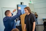 Gerardo Ochoa (left) gives Devin Thacker (right) his cords at an induction ceremony on May 18, 2023, for the Tri-Alpha Society, a national honor society for first-generation college students.