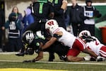 Oregon running back Jordon Davison, left, crosses into the end zone for a touchdown during the second half of an NCAA college football game against Wisconsin, Saturday, Oct. 25, 2025, in Eugene, Ore.