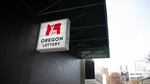 An Oregon Lottery sign hangs outside the Cheerful Tortoise bar in Portland, Ore., Nov. 24, 2018. The lottery has released a new sports betting smartphone app called Scoreboard.
