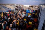 Palestinians displaced by the Israeli bombardment of the Gaza Strip queue for water at a makeshift tent camp in the southern town of Khan Younis, Monday, July 1, 2024.