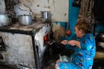 Daria Kuznetsova burns coal in her kitchen stove in Dobropillya, Ukraine, on Oct. 17.