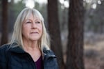 Terri Holm stands at the edge of the Deschutes National Forest in Bend, Ore., on Dec., 5, 2024. The national forest boundary is about a mile away from her home.