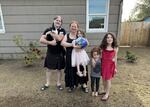 From left to right, Jon Dougherty (holding Moo the Cat), his wife Skye Malito, and their children, Luna, Willow, and Lucy, in their yard just a few hundred feet away from the defunct J.H. Baxter wood treatment plant that operated for more than 80 years. Earlier this year, contractors working for the DEQ removed six inches of soil after it was found to contain high levels of dioxins which can be hazardous if ingested over long periods of time.