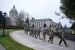 Washington National Guard members walk in formation away from the Legislative Building, Wednesday, Jan. 20, 2021, at the Capitol in Olympia, Wash. Members of the Guard and Washington State Patrol troopers have been in place all week on the campus providing security against possible protests connected with the inauguration of President Joe Biden and the departure of former President Donald Trump in Washington, D.C. (AP Photo/Ted S. Warren)
