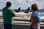 Travelers look out over grounded Air Canada planes as flight attendants picket at Pearson International Airport in Toronto, Monday.