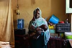 Maryam holds the 7-month-old child she gave birth to inside a refugee camp in Gezira, Sudan, on Dec. 10, 2023. She says "I traveled from Mayo, in southern Khartoum, to the city of Wad Madani. The trip took three days on a karoo [a wooden cart pulled by a donkey], and I was with my six children and was five months pregnant at the time."