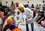 Sikh Temple of Wisconsin attendees enjoy food prepared by members Sunday, Sept. 22, 2024, in Oak Creek, Wis.