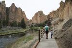 A man walks hand-in-hand with a small boy in Smith Rock State Park on May 16, 2020. 