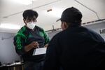 Dagoberto Morales writes down a student's contact information at the Únete Center for Farmworker Advocacy in Medford, Oregon, Sunday, April 25, 2021. Únete bases the assistance it provides community members on their needs.