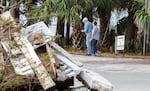 Voters walk through debris to vote in a new polling location after their regular polling place was damaged by Hurricane Michael in Wakulla Country, Fla., in November 2018.
