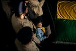 A young Lebanese boy holds a picture of Amal Hassan al-Durr, killed in an Israeli attack on Feb. 21, during her funeral the next day. A yellow Hezbollah flag was placed on Khadija Salman's casket by the party and a green Amal movement flag on Amal's casket.