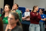 Attendees react to school closure plan announcements.