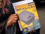 An attendee holds their free lockbox during a gun lockbox giveaway event on June 4, 2021 in Seattle, Washington.