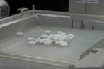 Pills sit in the tray of a pill-counting machine at 986 Pharmacy in Alhambra, Calif.