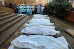 People mourn as they collect the bodies of Palestinians killed in an airstrike on December 13, 2023 in Khan Yunis, Gaza. More than 18,000 Palestinians have been killed, the majority of whom are women and children.