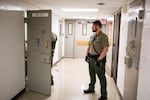 A Clackamas County sheriff's deputy stands in the hall of the Clackamas County Jail on Tuesday, Jan. 22, 2019, in Oregon City, Ore. “Suicide is the highest risk and the one we have the most control over,” said Capt. Lee Eby, commander of the Clackamas County Jail.
 