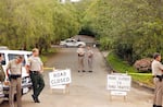 Police stand guard at the closed road at base of hill at the Rancho Santa Fe gated community in San Diego, Calif., scene of the Heaven's Gate cult mass suicide, March 28, 1997.