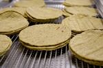 Freshly made green tortillas coming hot off the production line at Three Sisters Nixtamal in Portland, Ore., on July 20, 2022.