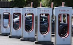 A Tesla charges at a Tesla Supercharger in Petaluma, Calif., in May. Tesla's Supercharger network has more than 30,000 fast-charging ports — more than half of all the EV fast chargers available in the United States. Until recently, they were only open to Tesla drivers, but that's changing.