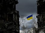 The Ukrainian flag flutters between buildings destroyed in bombardment in the Ukrainian town of Borodianka. It was one year ago last week that Russia invaded.