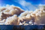 Saturday, Jan. 11: Smoke from the Palisades Fire rises over a ridge as seen from the Encino section of Los Angeles.
