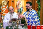 Rev. Father Christos Kalaitzis blesses holy water using a cross and rosemary branch at Holy Trinity Greek Orthodox Cathedral in Portland on Jan. 6, 2023. It was to celebrate Theophany an important holiday in the Orthodox church.