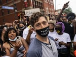 Minneapolis Mayor Jacob Frey leaves after speaking Saturday to demonstrators calling for the Minneapolis Police Department to be defunded. When asked whether he would agree to defund the police, Frey said no, and was then asked to leave the protest.