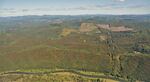 aerial image looks down on green forests turned orange on south-facing sides