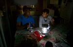 The Johnsons use electric lanterns to prepare a meal in the dark at their home in Southeast Portland.