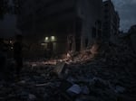 Palestinians inspect the destroyed buildings after a rocket attack by Israeli air forces targeting a shopping center in the Gaza Strip, Gaza.