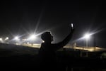 A displaced Palestinian uses an eSIM card in an attempt to get a signal to contact his relatives on a hill in Rafah on Jan. 19.