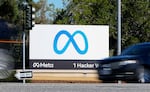 FILE - A car passes Facebook's new Meta logo on a sign at the company headquarters on Oct. 28, 2021, in Menlo Park, Calif.