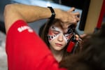 Camryn Schmick, 11, gets her face painted before the game.