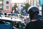 A pro-Trump caravan winds its way through downtown Portland, Ore., clashing with counterprotesters on Aug. 30, 2020. Some in the caravan used cars to drive through crowds of people and others shot paintball guns and mace from truck beds.