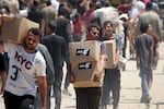 People carry boxes of relief supplies