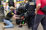 Todd Kelsay, left, assisted federal law enforcement officers in restraining and handcuffing an antifa protester outside of a pro-Trump free speech rally in Portland on Sunday, June 4, 2017. Kelsay's involvement in the arrest has sparked an investigation by the U.S. Attorney's Office. 