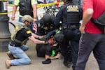 Todd Kelsay, left, assisted federal law enforcement officers in restraining and handcuffing an antifa protester outside of a pro-Trump free speech rally in Portland on Sunday, June 4, 2017. Kelsay's involvement in the arrest has sparked an investigation by the U.S. Attorney's Office.