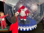 Rev. Dr. Leroy Barber visits with children as Santa Claus through a 10-foot-tall inflatable snow globe in Portland, Ore.