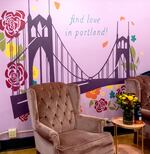 Grand Gesture Books provides a seating area for readers in front of a painted wall that reads, "Find love in Portland," on Oct. 26, 2024 in Portland, Ore. Grand Gesture is Oregon's first romance-only bookstore.