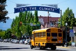 A Grants Pass School District 7 school bus drives under a city slogan sign, Thursday, May 18, 2023, in Grants Pass, Ore.