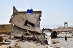 People stand by homes damaged by flooding after heavy rains, on the outskirts of Quetta, Pakistan, Aug. 27. Pakistani authorities say some 33 million people have been affected by this year's catastrophic floods.