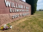 A bunch of flowers Tuesday afternoon lay near the sign for William Wiley Elementary School in West Richland. Students returned to class on Wednesday morning with therapy dogs and counselors.