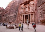 A tourist rides a camel at the Treasury site in Petra, Jordan, in December 2022. Archaeologists have discovered a hidden tomb at the site.