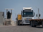 An Israeli border guard watches as trucks drive from Gaza into the Gaza side of the Kerem Shalom border crossing. The trucks are loaded and then return to Gaza.