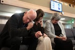 Thom Bishop, left, wipes his eyes while praying with his wife, Donna Bishop, center, and Leann Damian during the service at Victory Baptist Church.