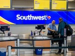 A Southwest Airlines employee assists a passenger during their check-in at the Austin-Bergstrom International Airport on April 18 in Austin, Texas.