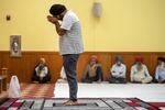 A man lowers his head in prayer at the temple.