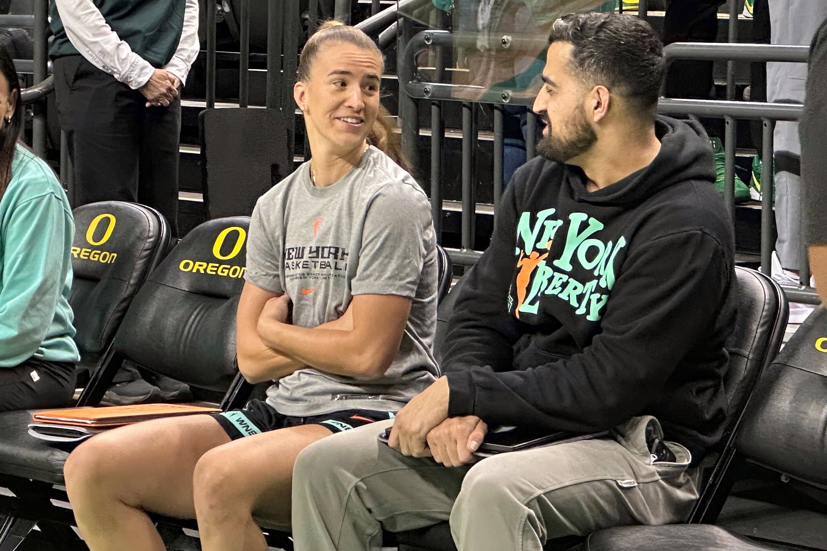 New York Liberty guard Sabrina Ionescu, left, talks with assistant coach Zach O'Brien, right, before a preseason WNBA basketball game against the Toyota Antelopes, of Japan, in Eugene, Oregon, Monday, May 12, 2025.