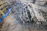 Sun., Oct. 8: People inspect the ruins of a building destroyed in Israeli strikes.